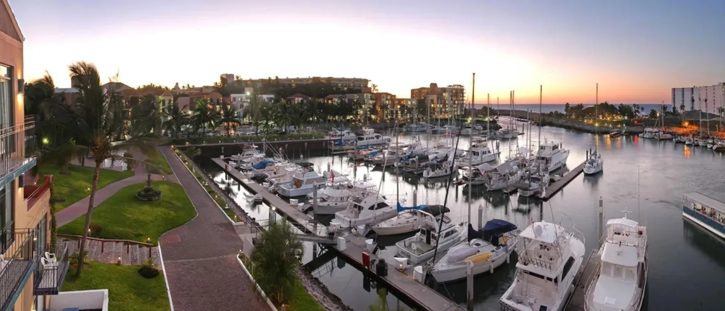 Sunset view over the marina docks and yachts at El Cid Marina Beach Hotel.