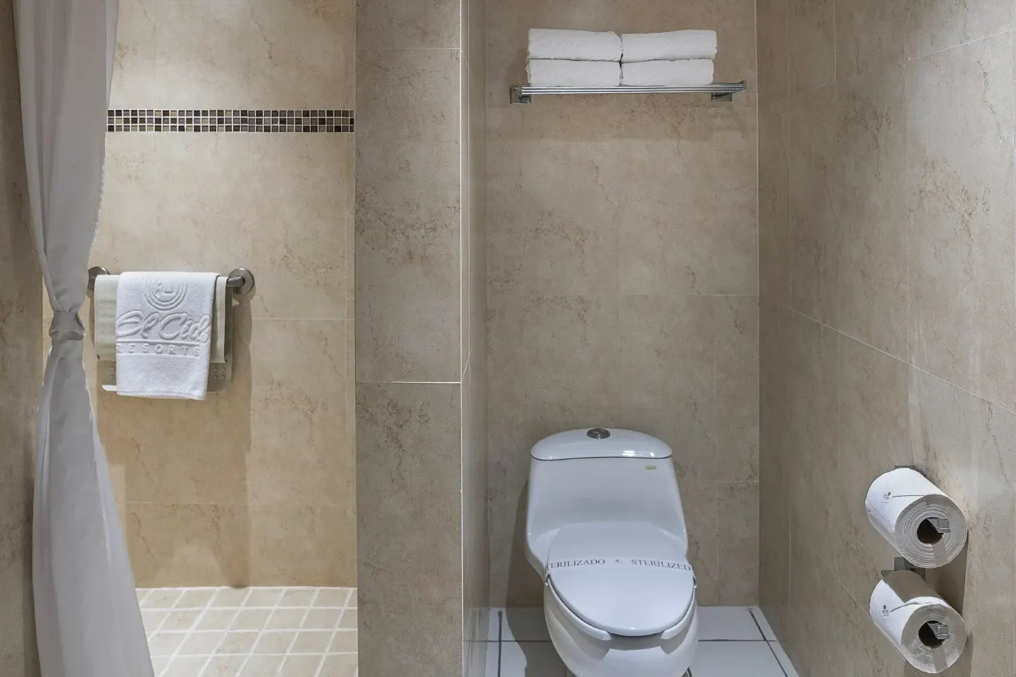 Junior Suite bathroom with toilet, towel shelf, and shower area at El Cid Marina Beach Hotel.