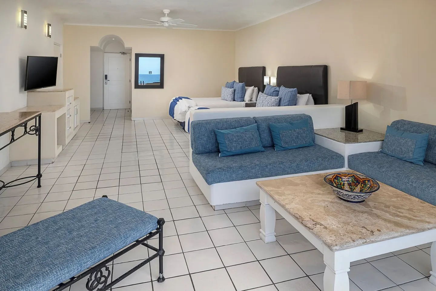 Junior Suite with lounge seating, two beds, and TV at El Cid Marina Beach Hotel.