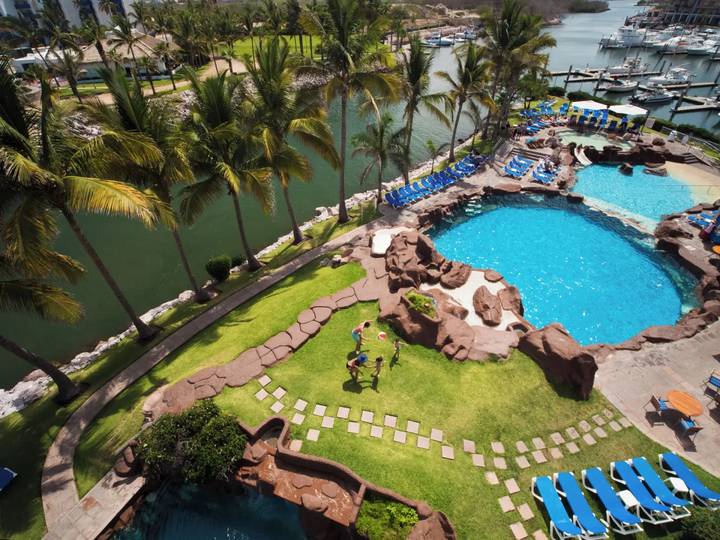 View of pool, marina, palms, and grounds from a Junior Suite at El Cid Marina Beach Hotel.