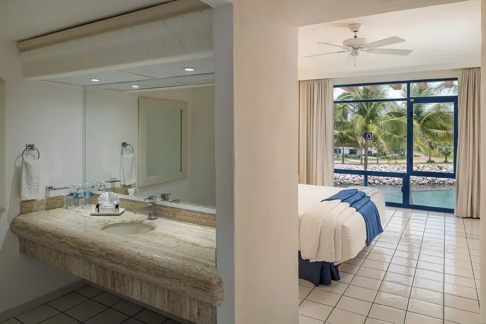 One Bedroom Suite bathroom vanity beside bedroom at El Cid Marina Beach Hotel.