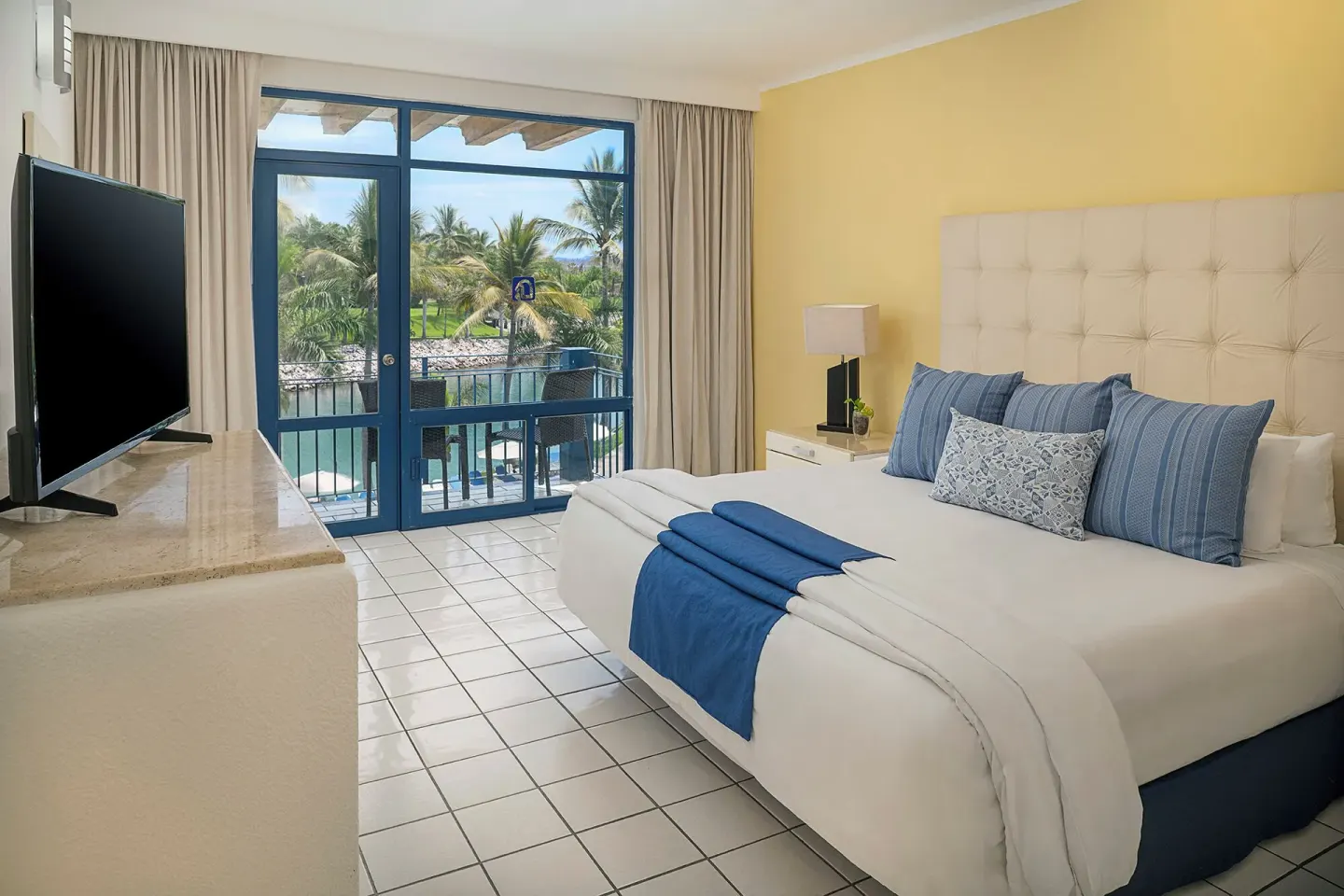 One Bedroom Suite king bed and balcony at El Cid Marina Beach Hotel.
