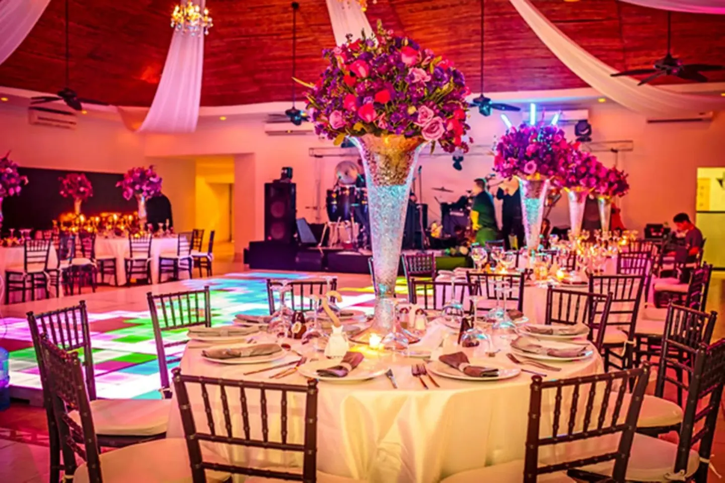 Reception ballroom with floral centerpieces at El Cid Marina Beach Hotel.