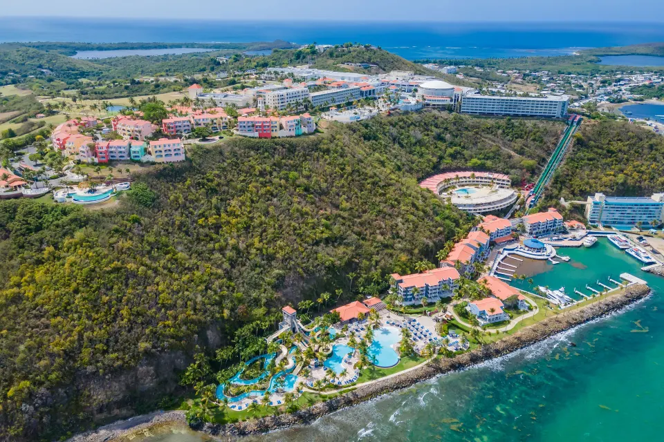 Aerial view of El Conquistador Resort on the coast with marina and pools.