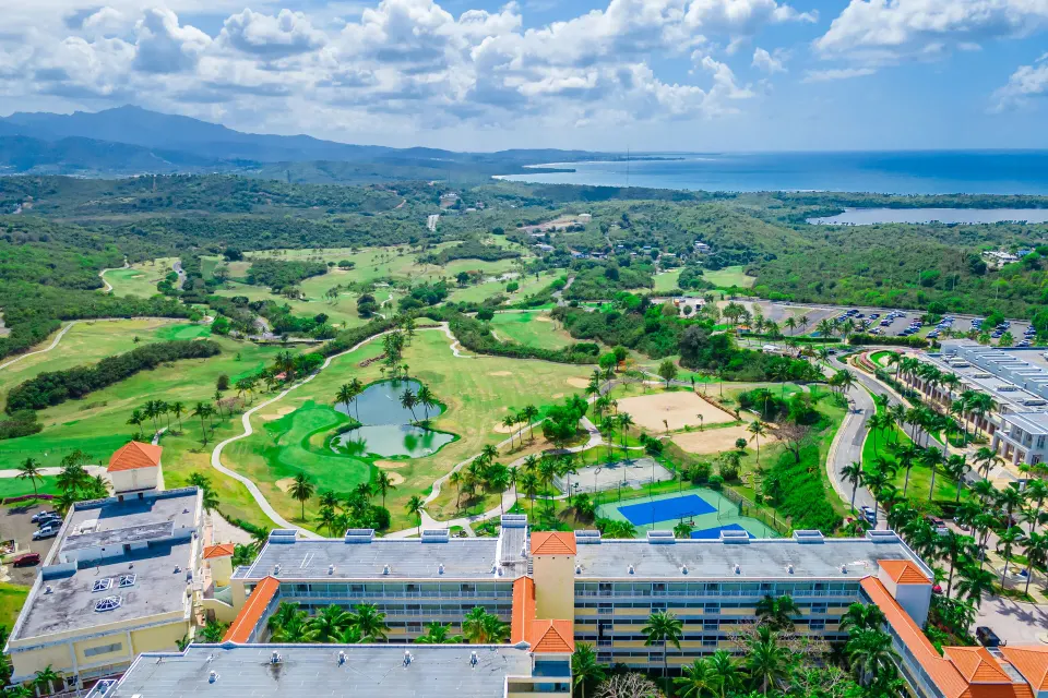 Aerial view of resort buildings, golf course, and coastline at El Conquistador Resort.