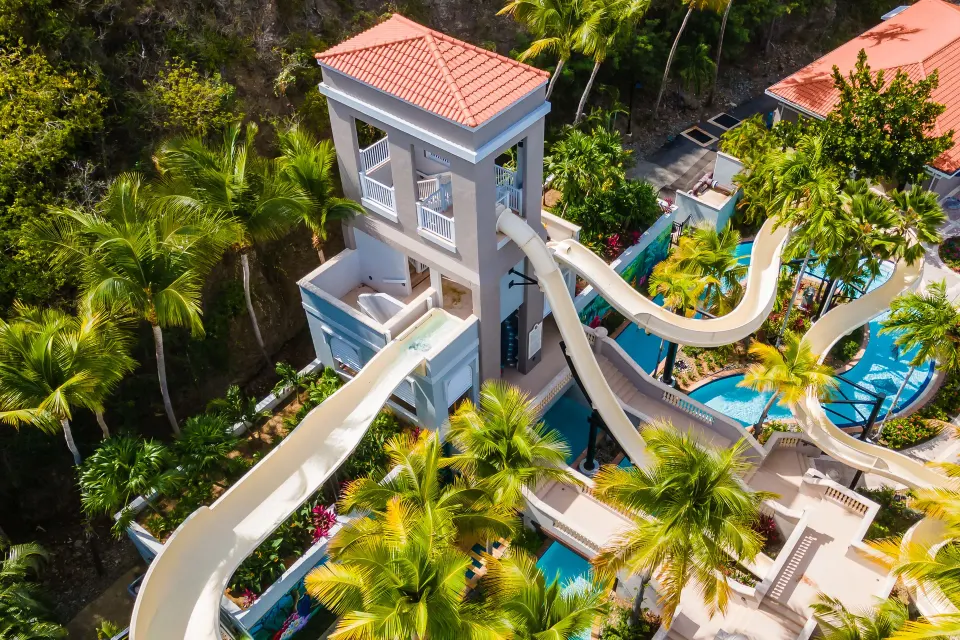 Aerial view of tower waterslides and palm-filled pool area at El Conquistador Resort.