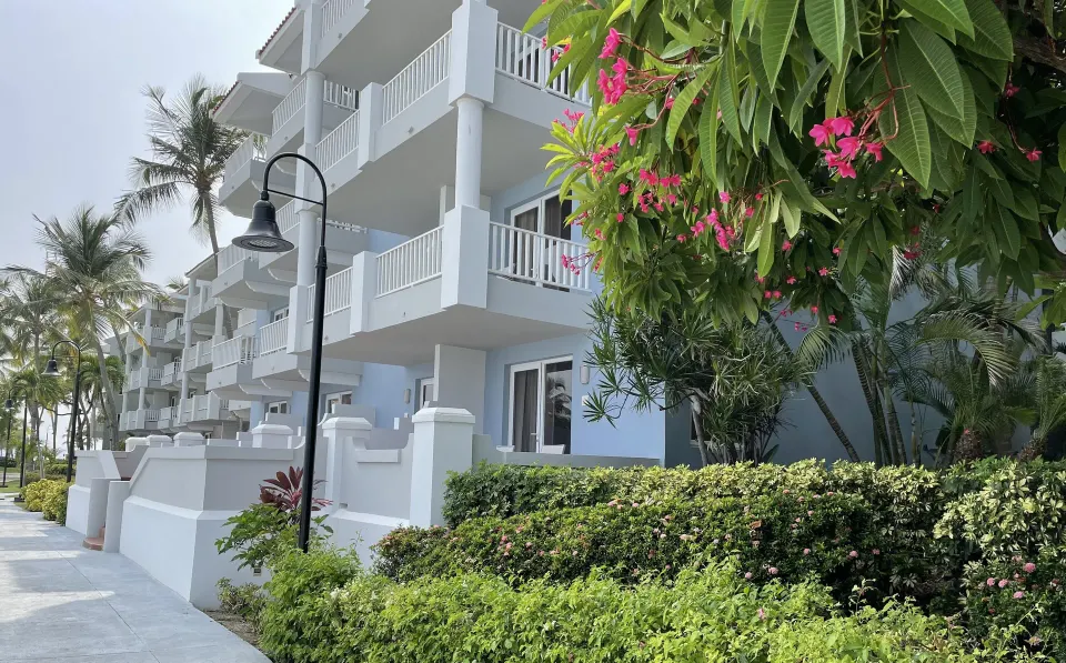 White balcony guestroom building with tropical landscaping at El Conquistador Resort.