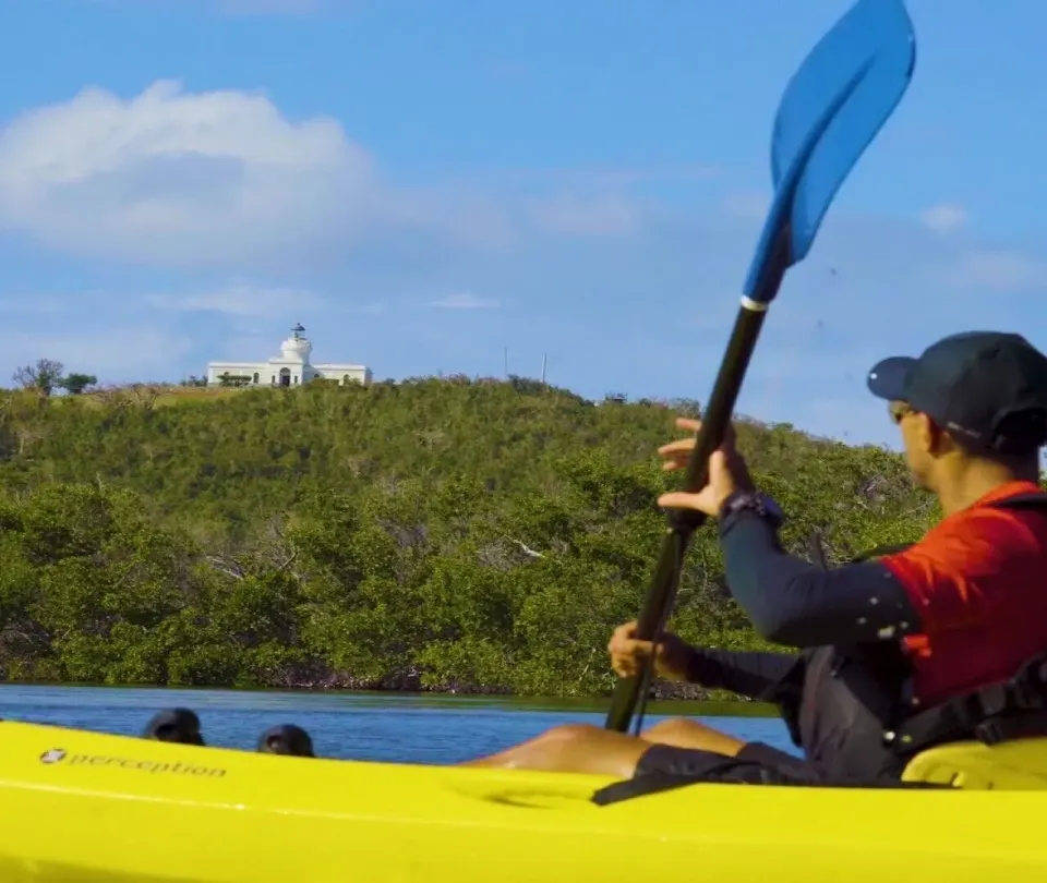Kayaker paddling on coastal water near El Conquistador Resort.