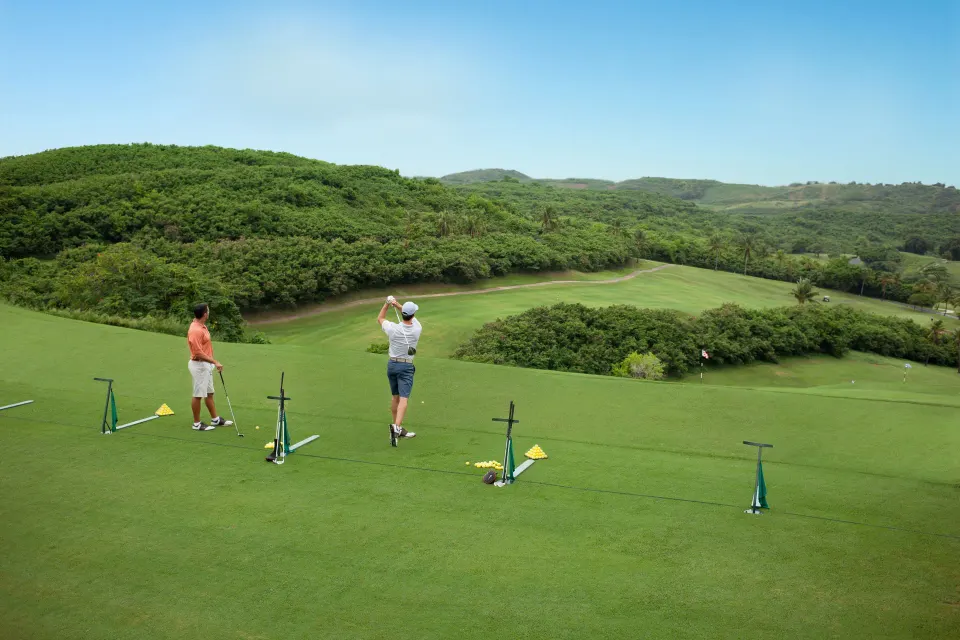 Golfers practicing from a raised tee area at El Conquistador Resort.