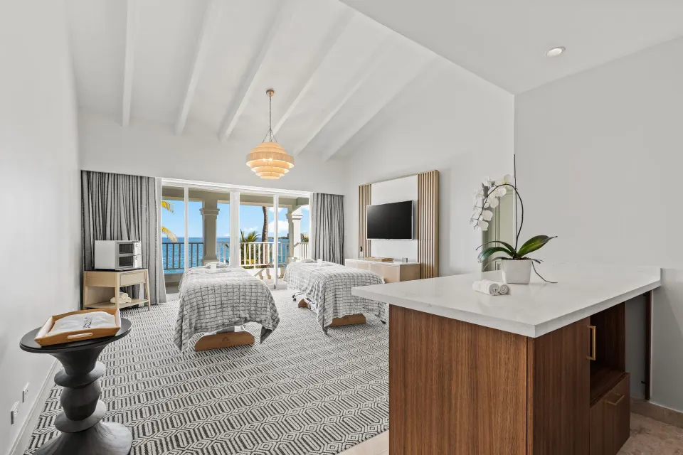 Guest room with two beds, balcony, and ocean view at El Conquistador Resort.