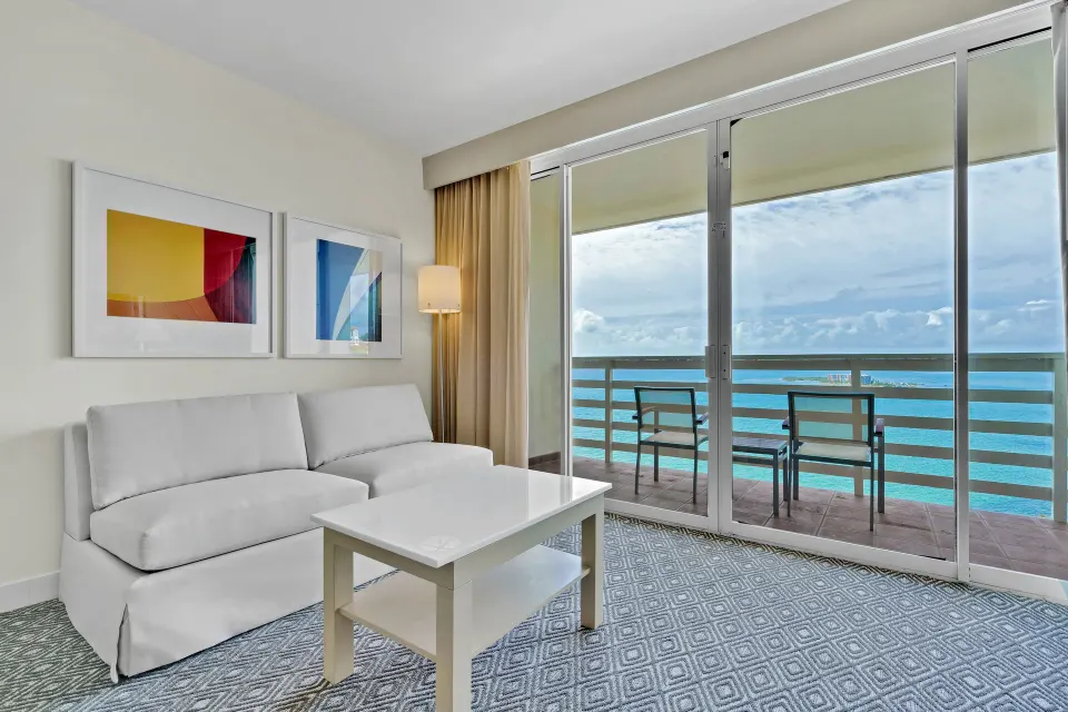 Sofa seating by sliding glass doors and an oceanfront balcony at El Conquistador Resort.
