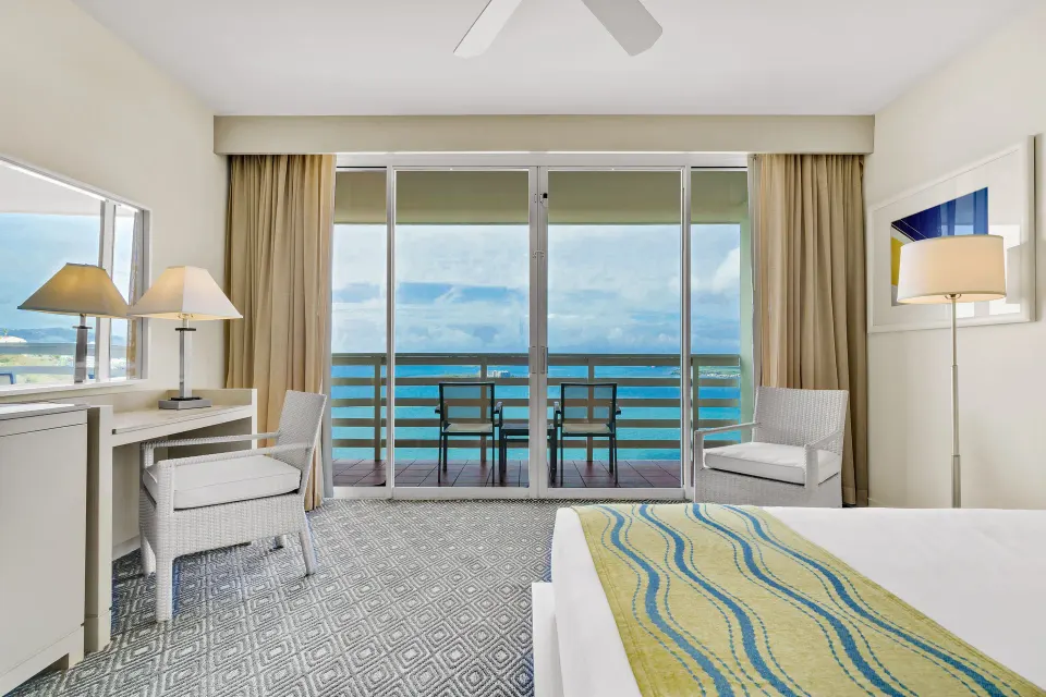 King bed guest room balcony with ocean view at El Conquistador Resort.