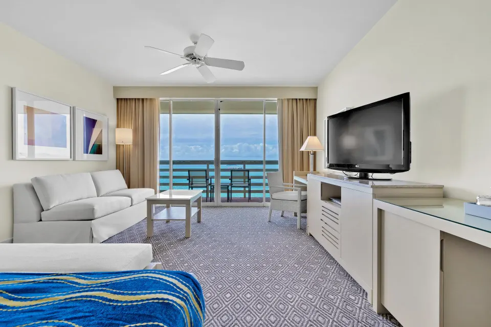 Ocean view suite with sofa, TV, and balcony at El Conquistador Resort.