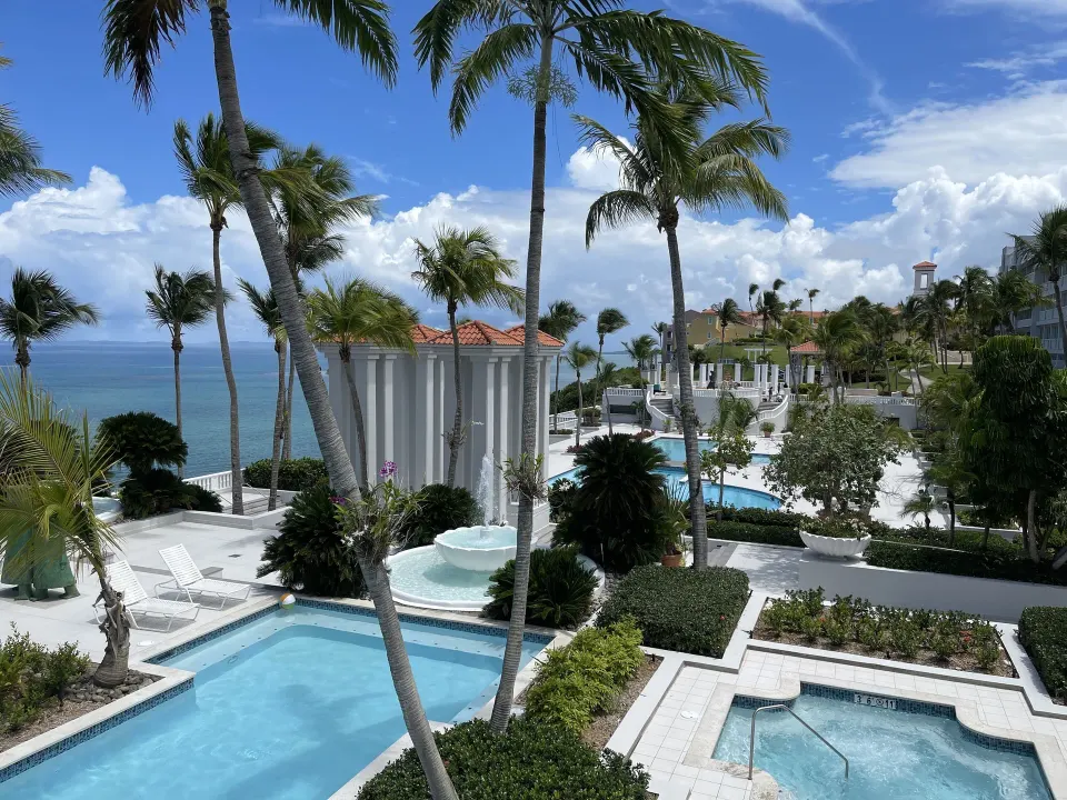 Palm-lined pools beside the ocean at El Conquistador Resort.