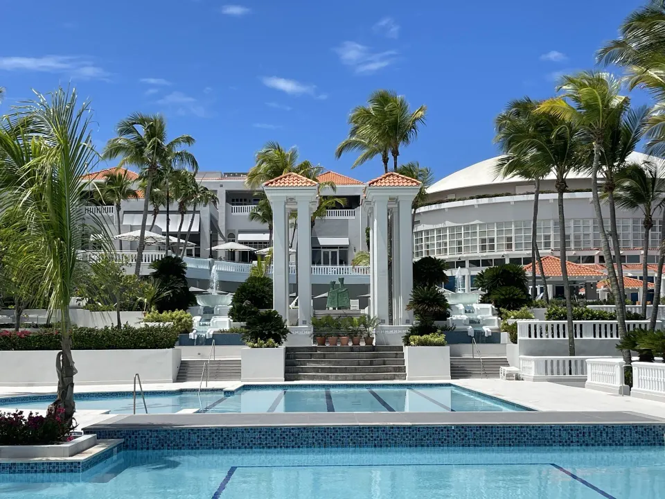 Tiered resort pool and white colonnades at El Conquistador Resort.