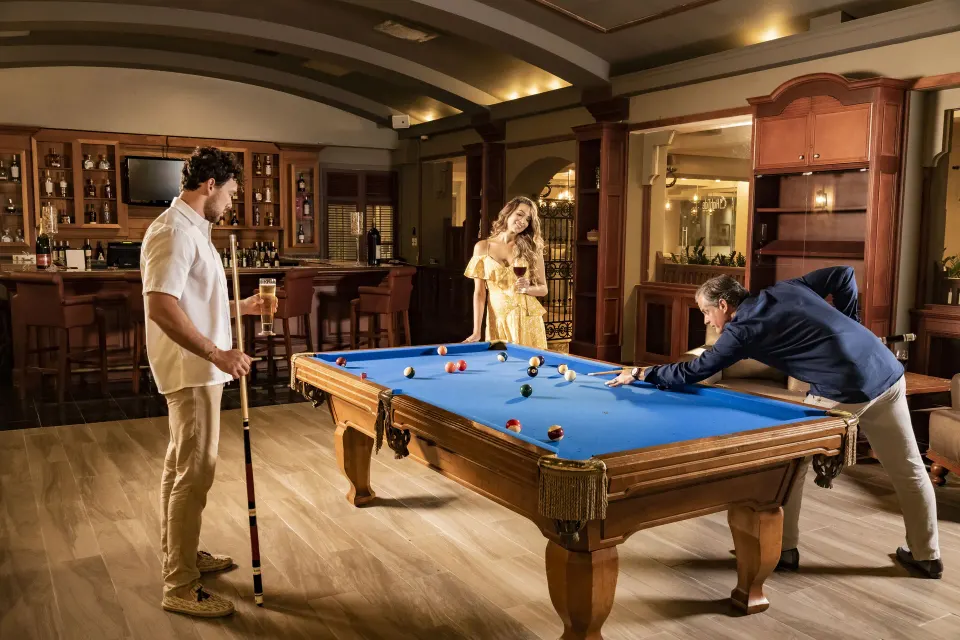 Guests play billiards beside a wood bar in a lounge at El Conquistador Resort.