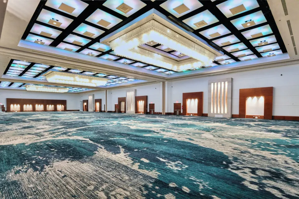 Large ballroom with blue patterned carpet and illuminated ceiling at El Conquistador Resort.