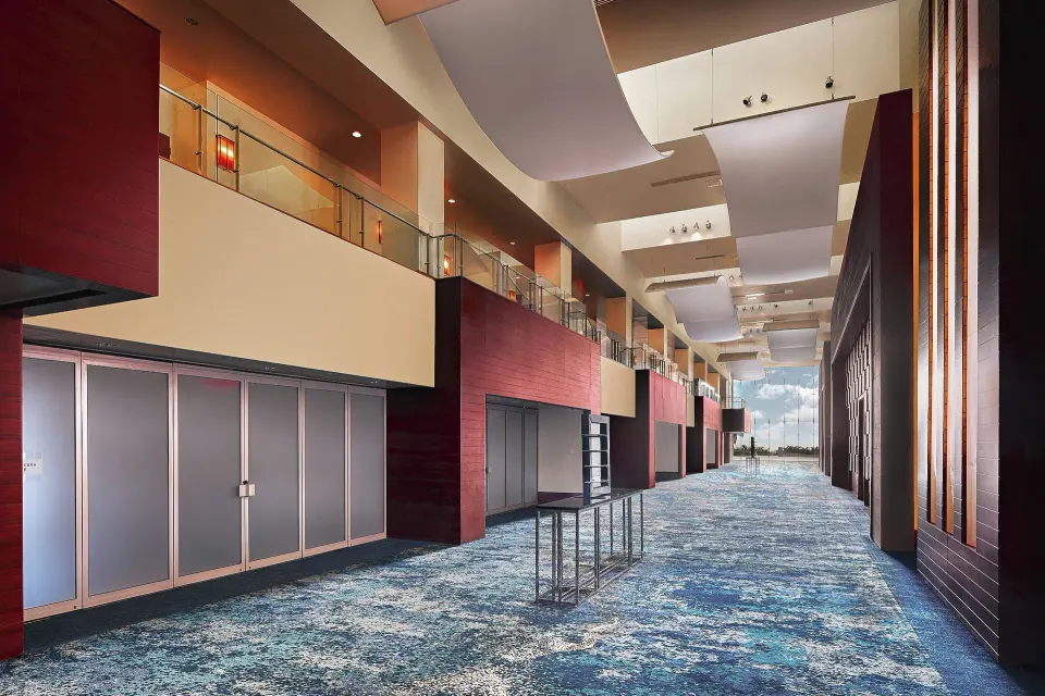 Modern event corridor with blue carpet and tall ceilings at El Conquistador Resort.