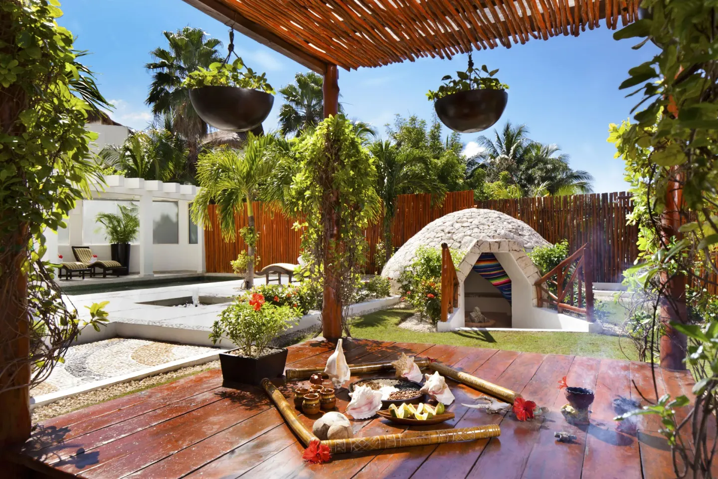 Garden ritual space with wooden deck, hanging planters, and a small dome at El Dorado Casitas Royale.