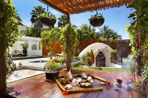Garden ritual space with wooden deck, hanging planters, and a small dome at El Dorado Casitas Royale.
