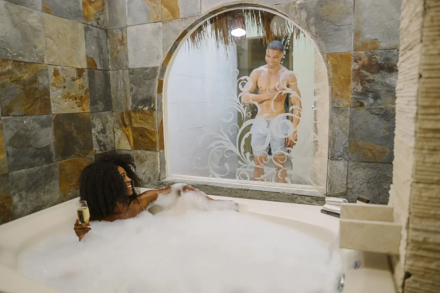 A jetted bathtub with bubbles and a garden-view window at El Dorado Casitas Royale.
