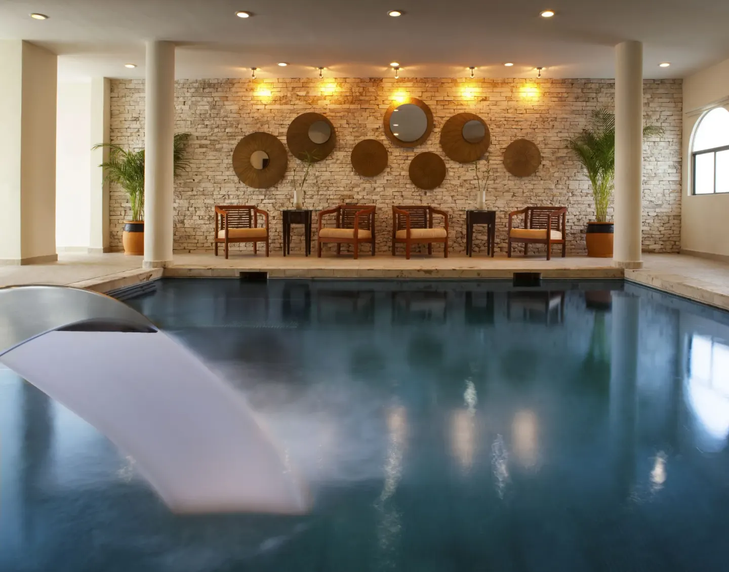 Indoor pool with curved water feature and stone accent wall at El Dorado Casitas Royale.