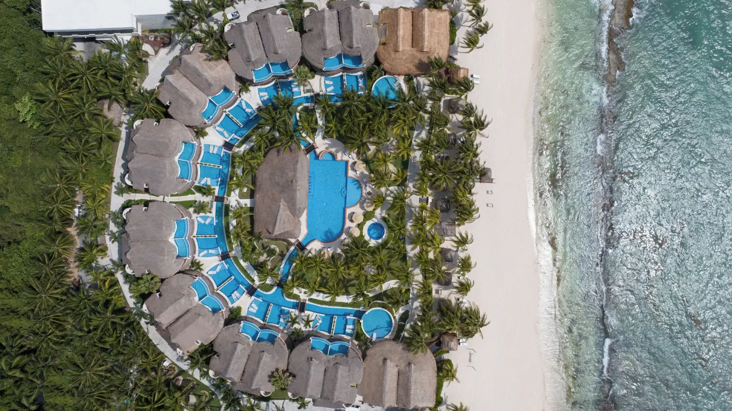 An overhead view shows beachfront casitas and pools at El Dorado Casitas Royale.