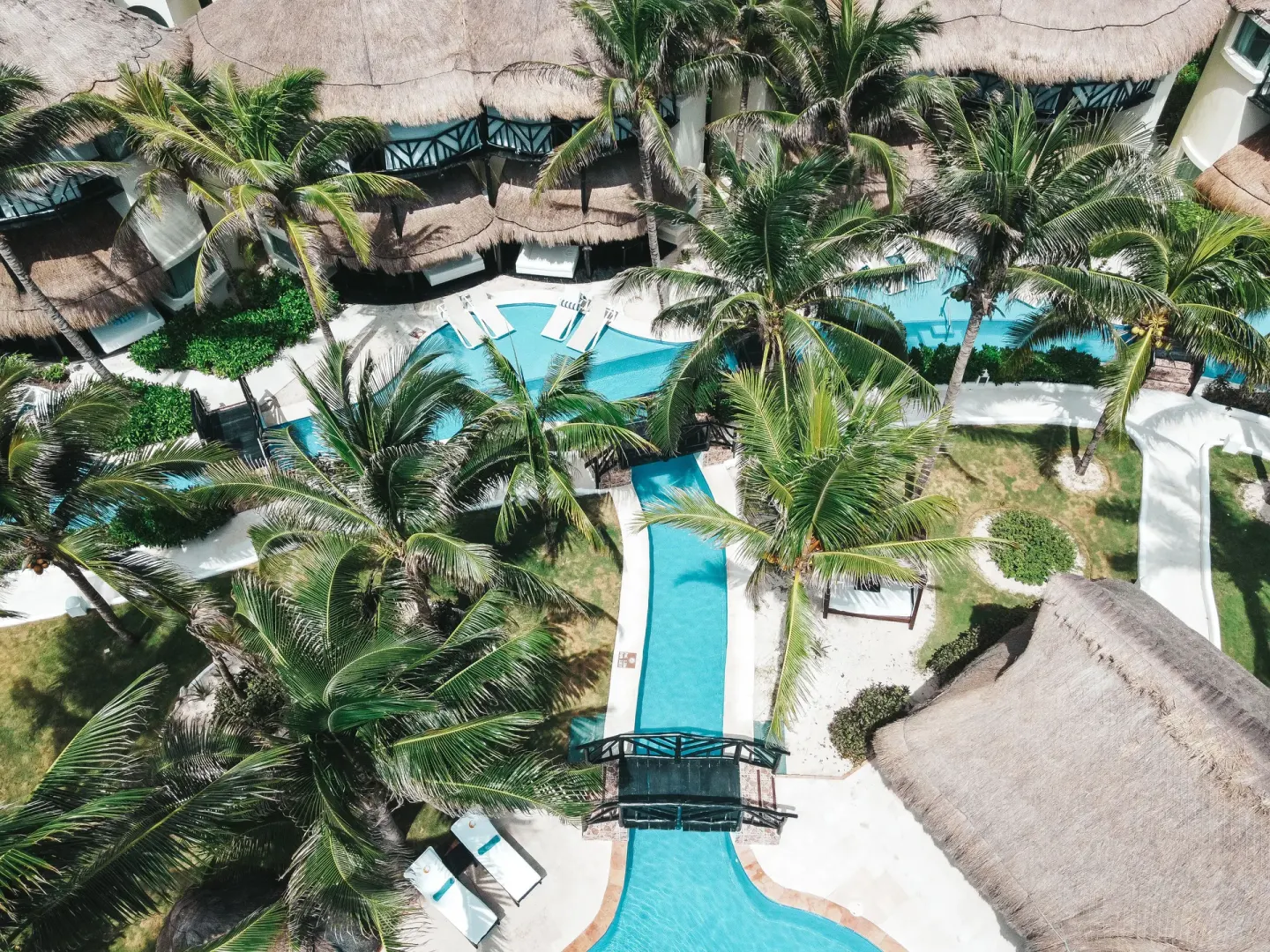 Aerial view of palm-lined pools and thatched casitas at El Dorado Casitas Royale.
