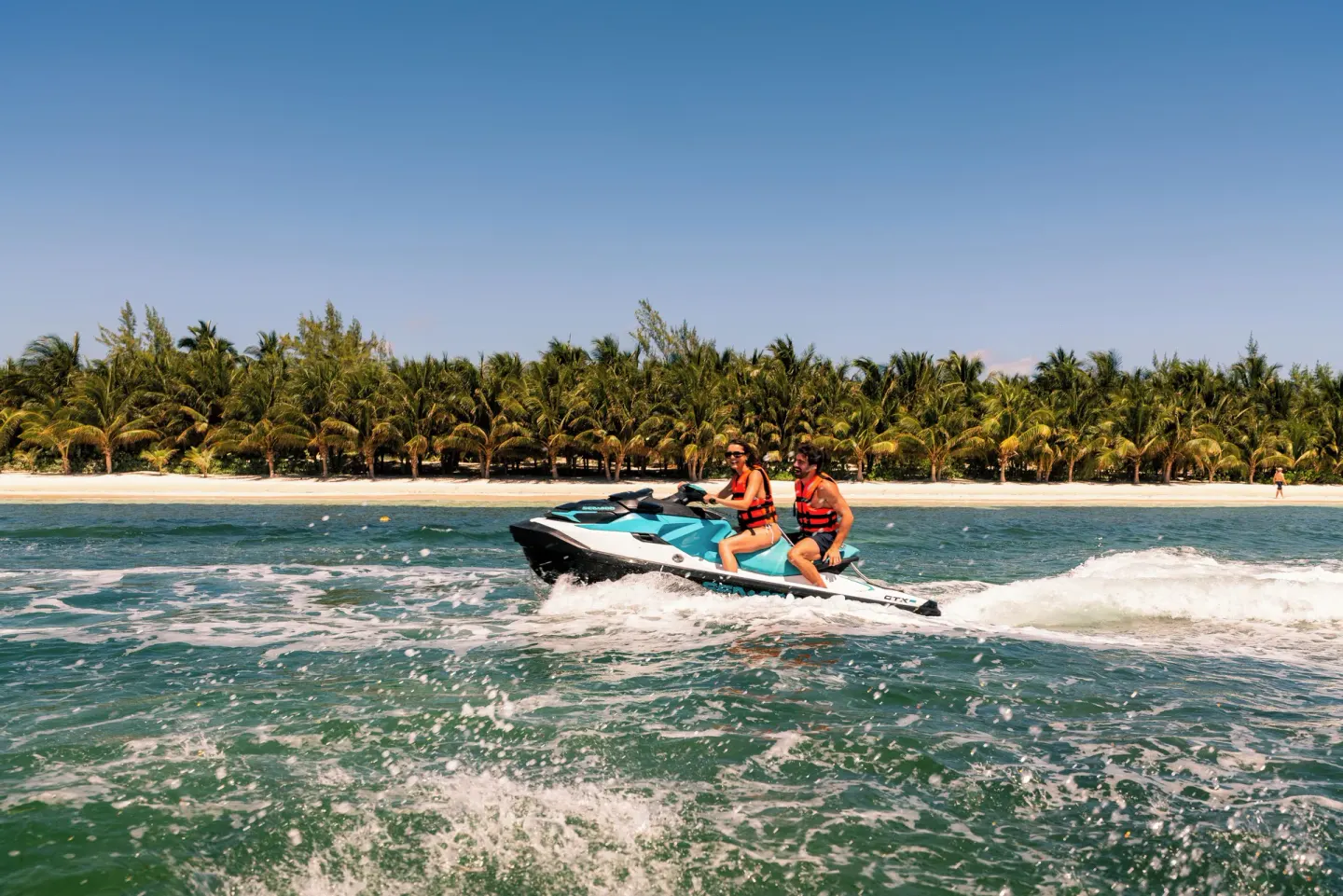Two riders on a personal watercraft off the beach at El Dorado Casitas Royale.