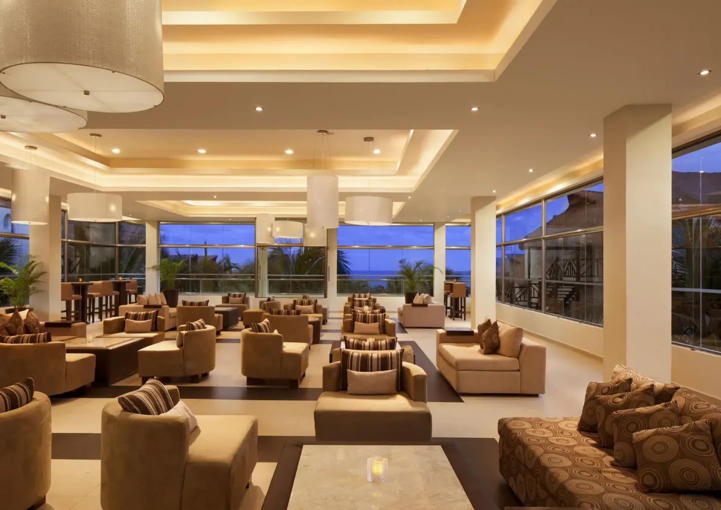 A spacious lounge with sofas and large windows at El Dorado Casitas Royale.