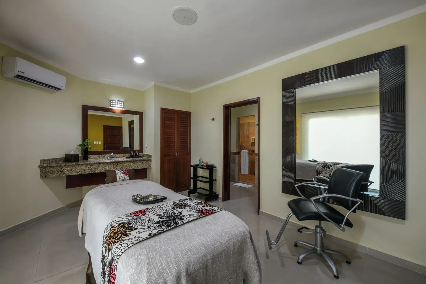 Spa treatment room with massage table and salon chair at El Dorado Casitas Royale.