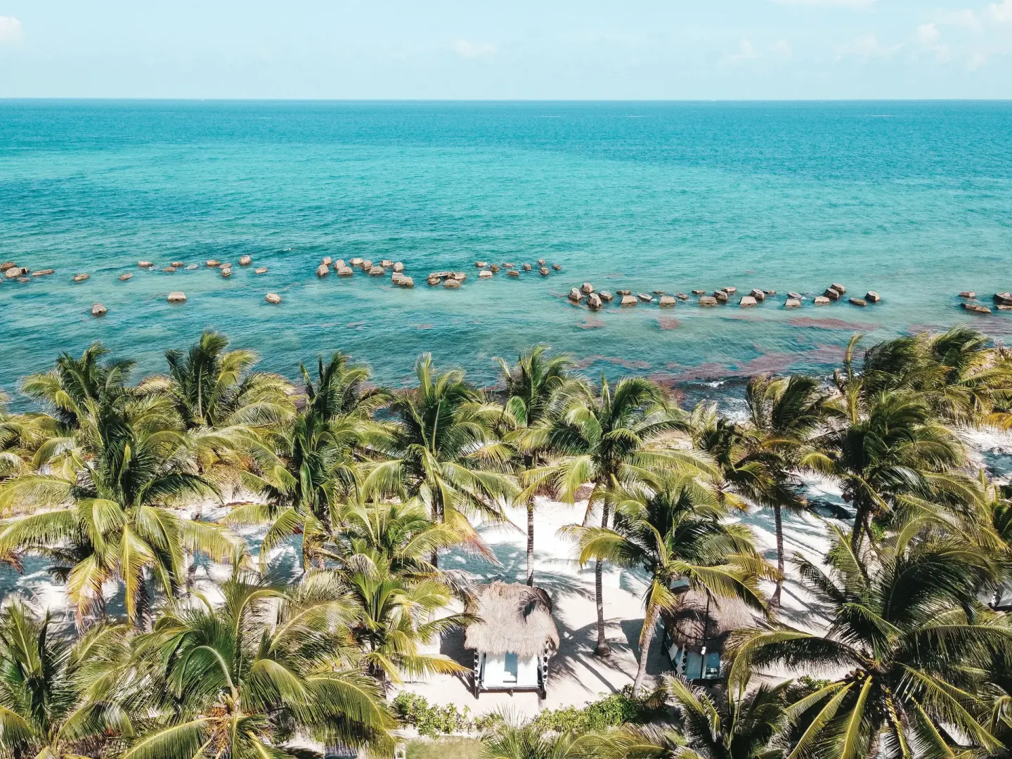 Turquoise sea, palms, sand, and beach cabanas at El Dorado Casitas Royale.
