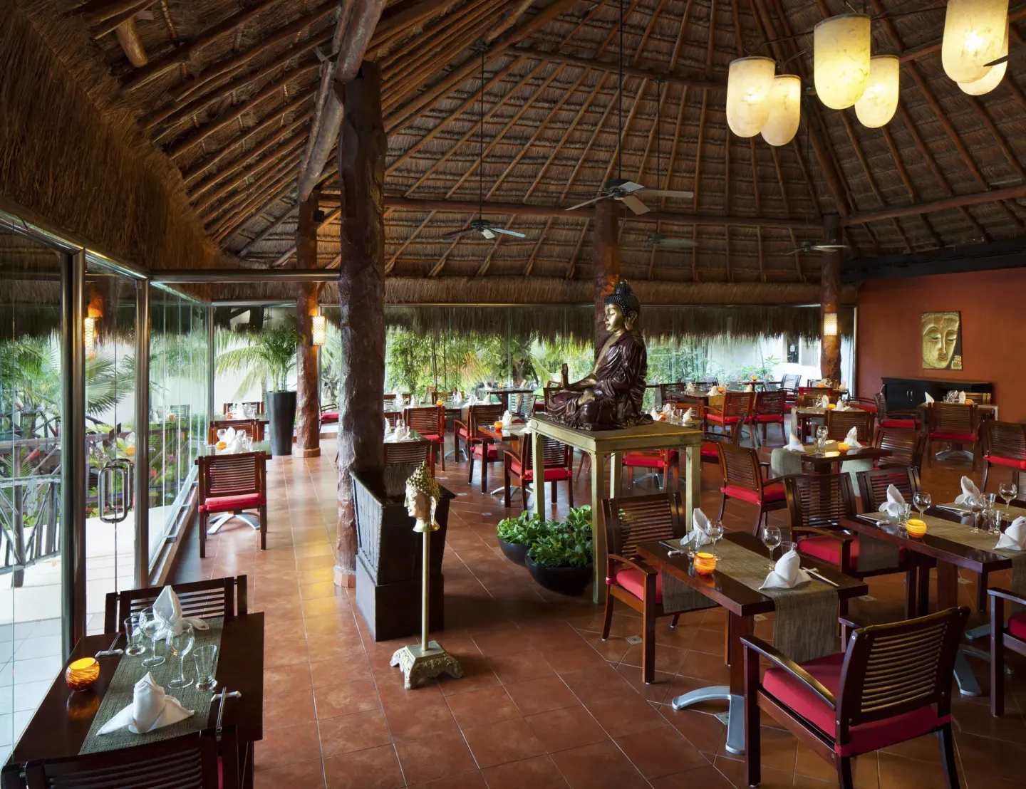 An Asian-style dining room with red chairs and a central statue at El Dorado Casitas Royale.