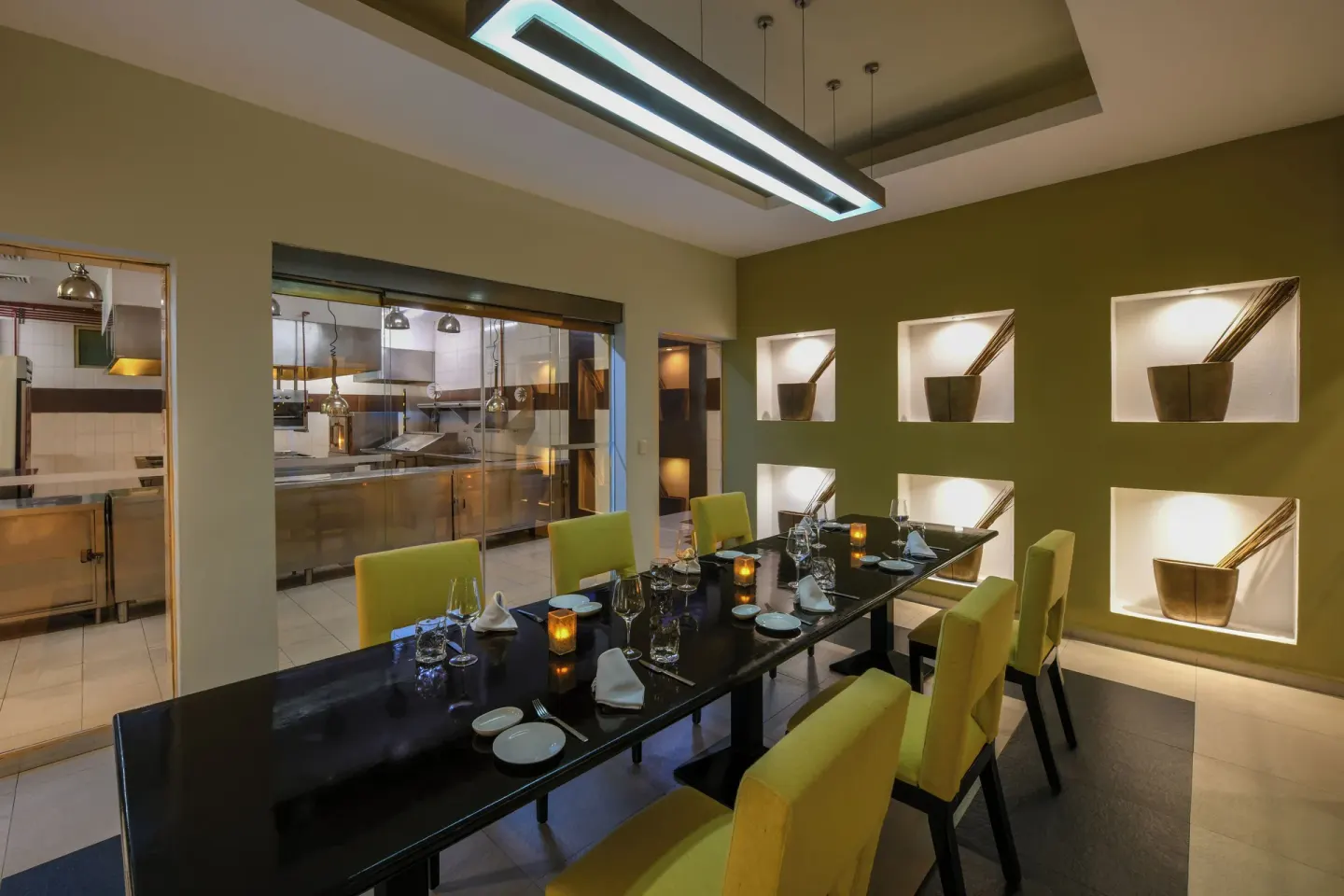 A private dining room with a kitchen view and yellow chairs at El Dorado Casitas Royale.