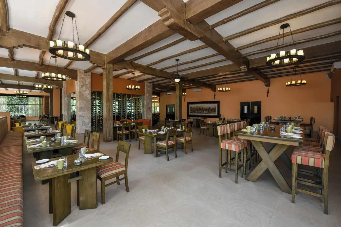 Wood-beamed restaurant dining room with set tables at El Dorado Casitas Royale.