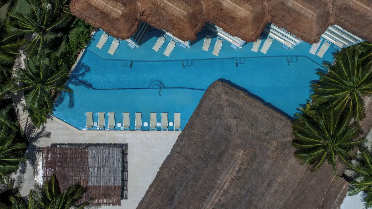 An aerial view shows a long resort pool at El Dorado Maroma Cenote, Underground Expedition.