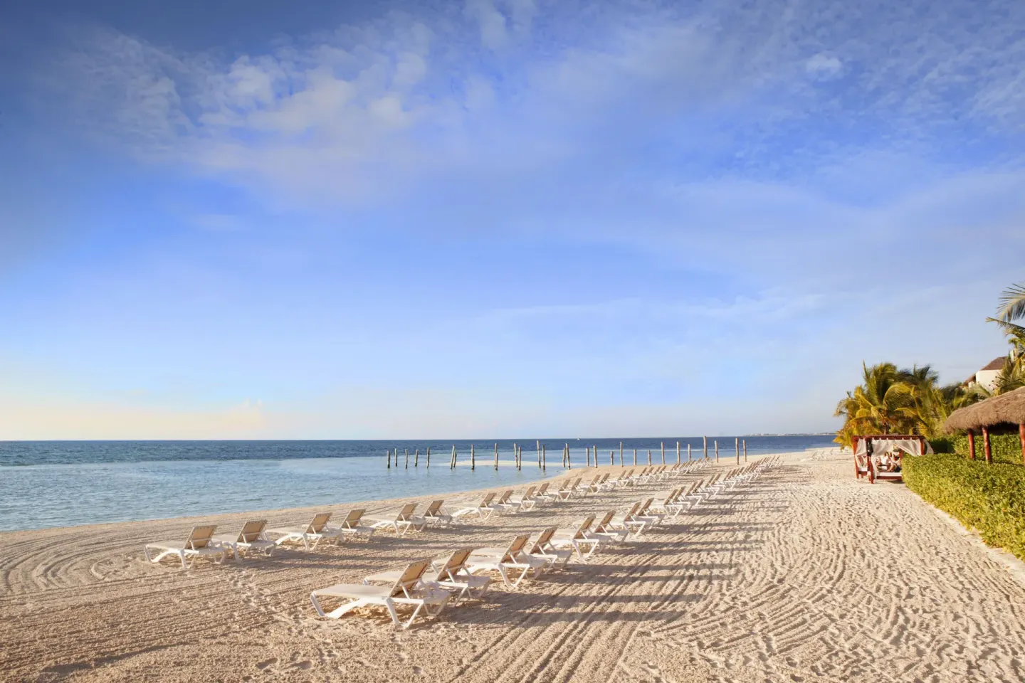 Rows of beach loungers line the shore at El Dorado Maroma Cenote, Underground Expedition.