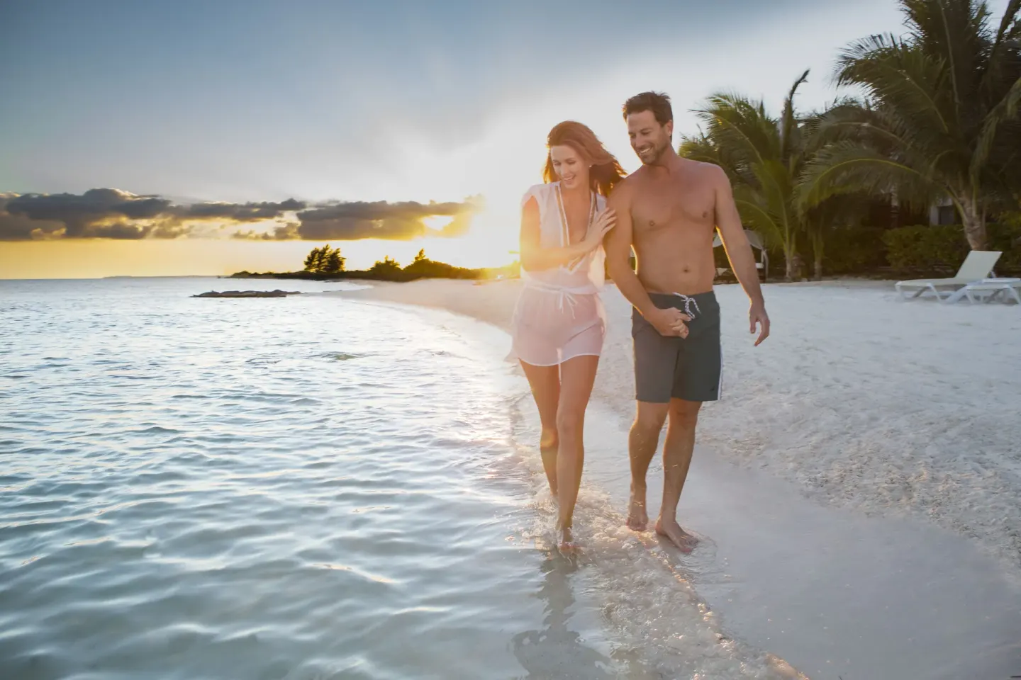 Couple walking in shallow surf at El Dorado Maroma Cenote, Underground Expedition.