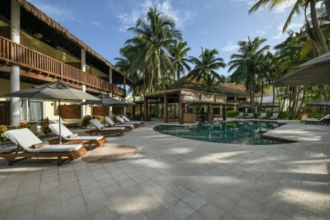 Courtyard pool with loungers and palms at El Dorado Maroma Cenote, Underground Expedition.
