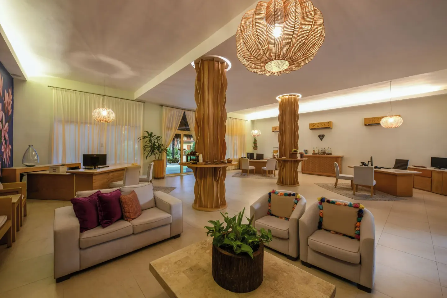 Lobby seating area with woven lights and carved columns at El Dorado Maroma Cenote, Underground Expedition.