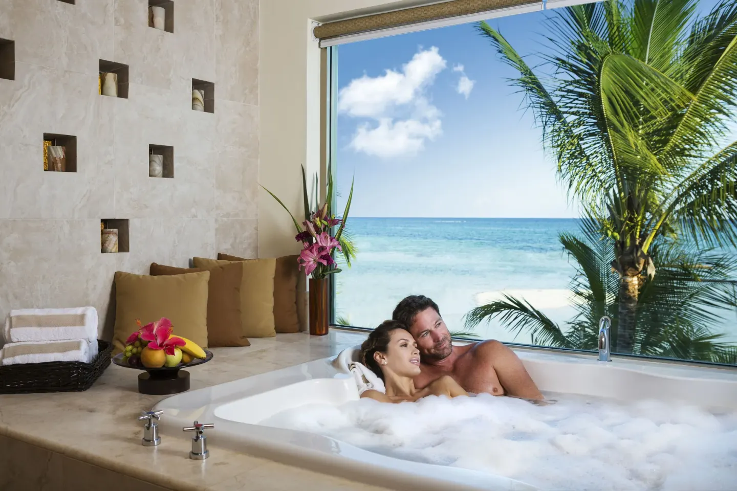 Couple in a soaking tub facing the sea at El Dorado Maroma Cenote, Underground Expedition.