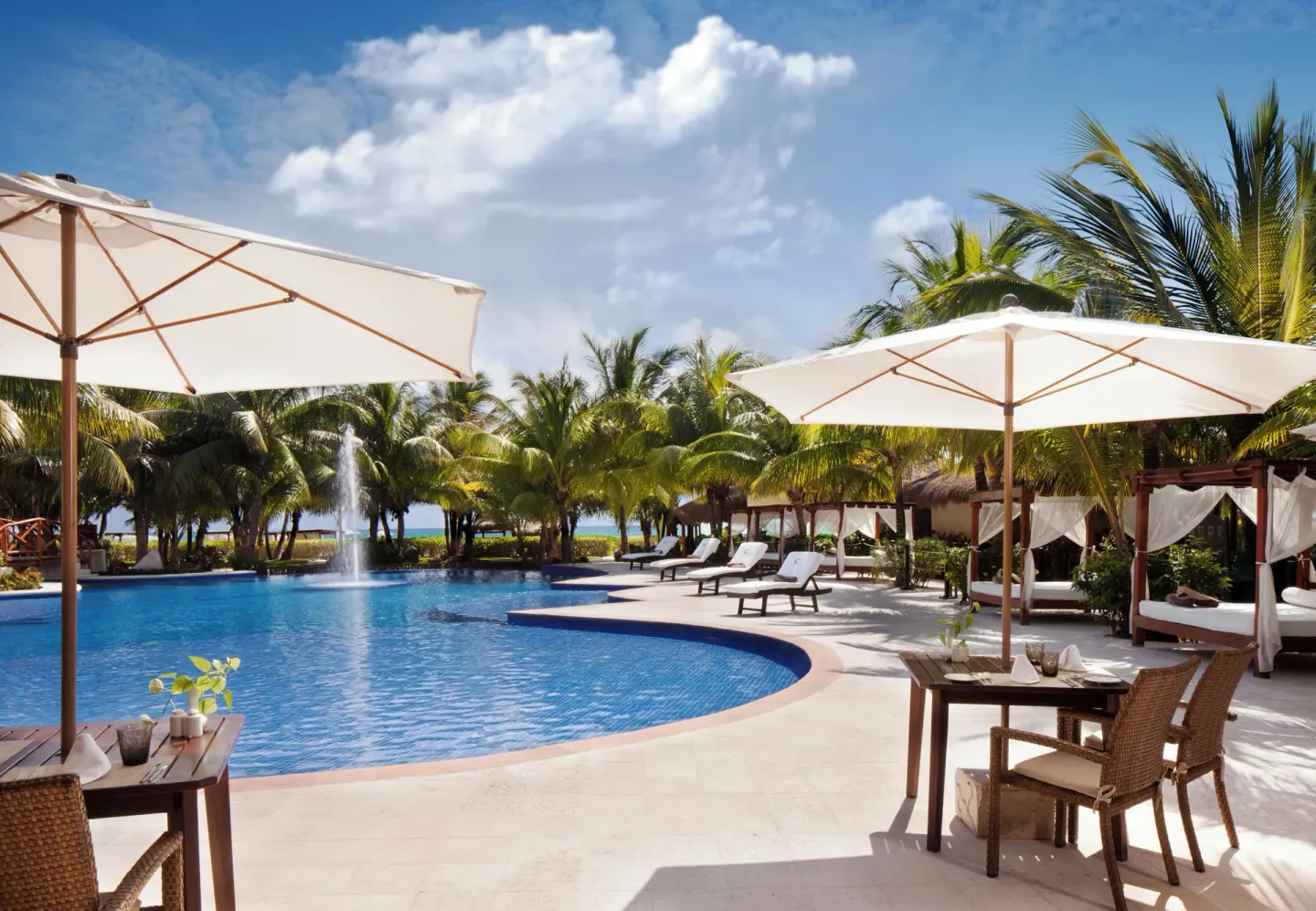 Poolside tables, umbrellas and cabanas at El Dorado Maroma Cenote, Underground Expedition.