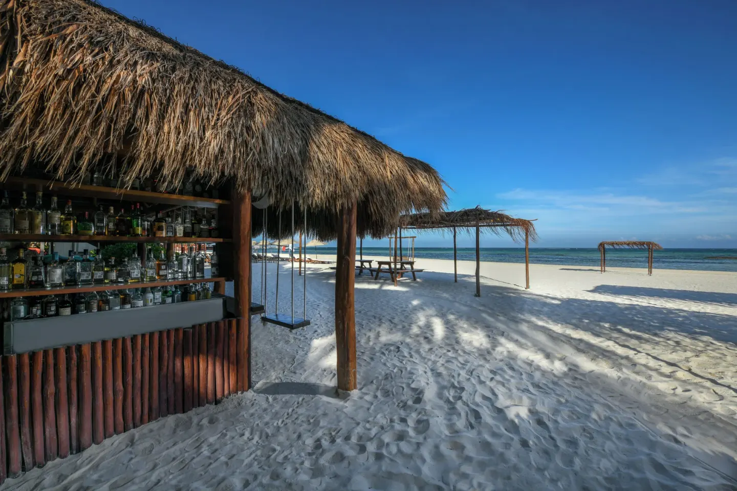 Thatched beach bar on the sand at El Dorado Maroma Cenote, Underground Expedition.