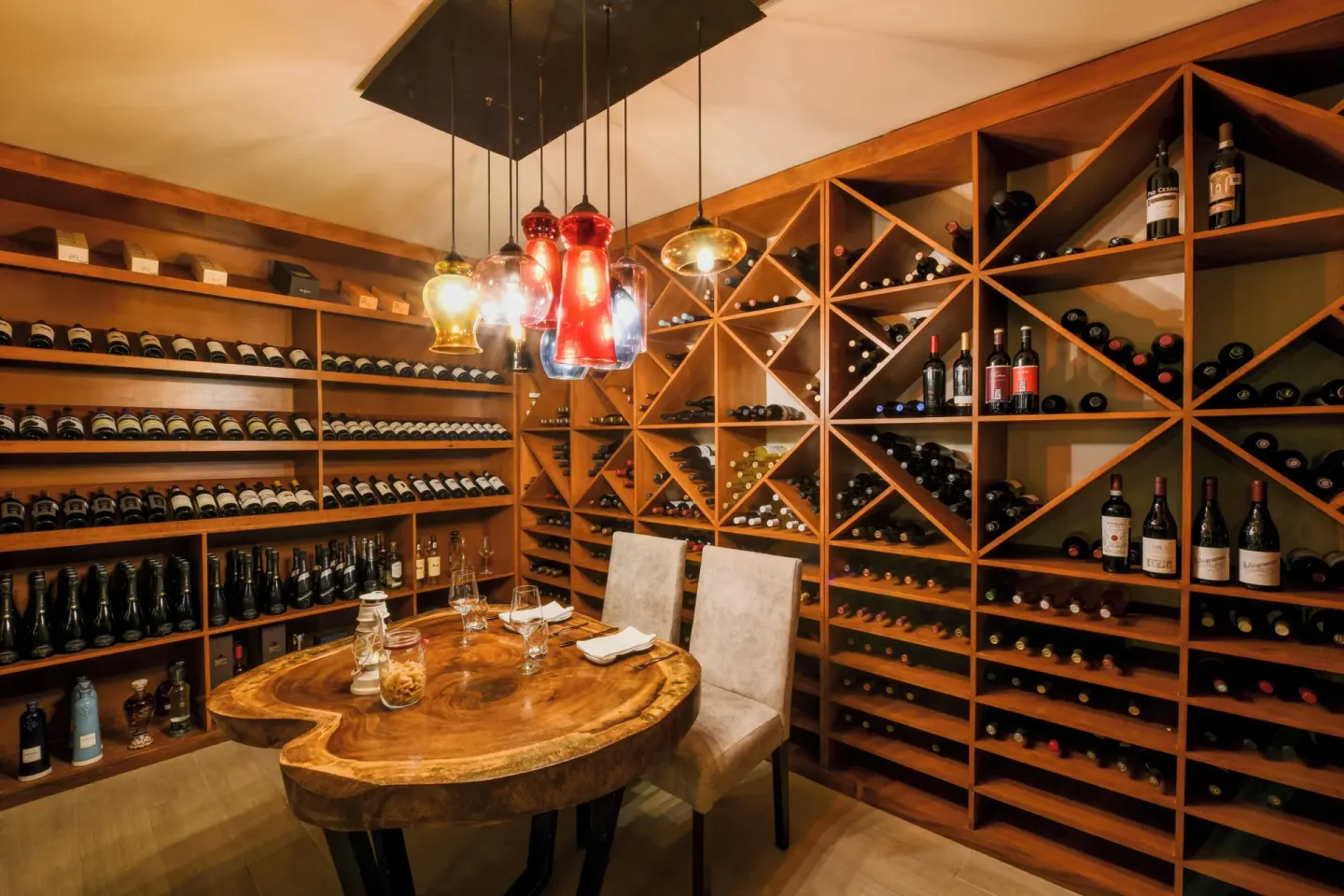Wine cellar dining table with bottle racks at El Dorado Maroma Cenote, Underground Expedition.