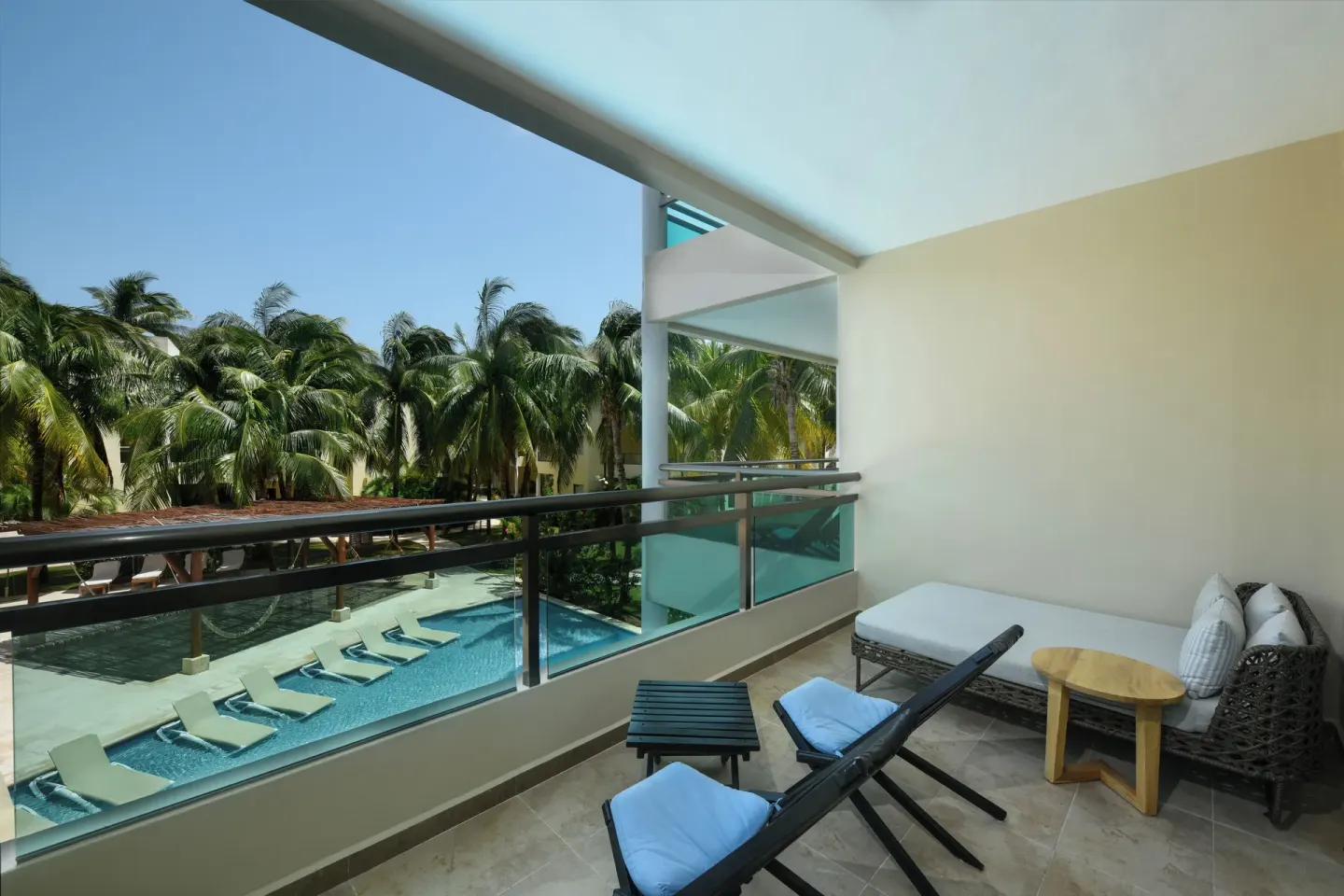 Junior Suite balcony with loungers and pool view at El Dorado Maroma Cenote, Underground Expedition.