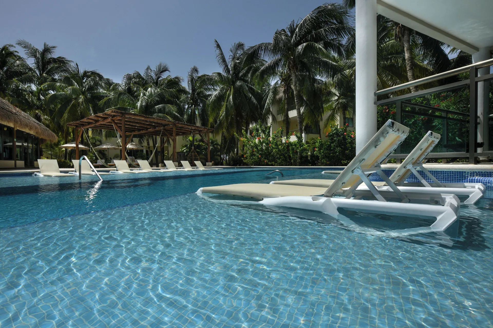 Swim Up Suite pool loungers in the water at El Dorado Maroma Cenote, Underground Expedition.