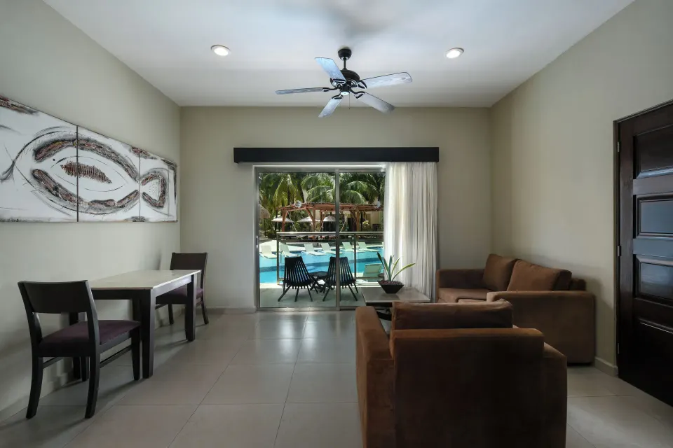 Swim Up Suite sitting and dining area by the pool at El Dorado Maroma Cenote, Underground Expedition.