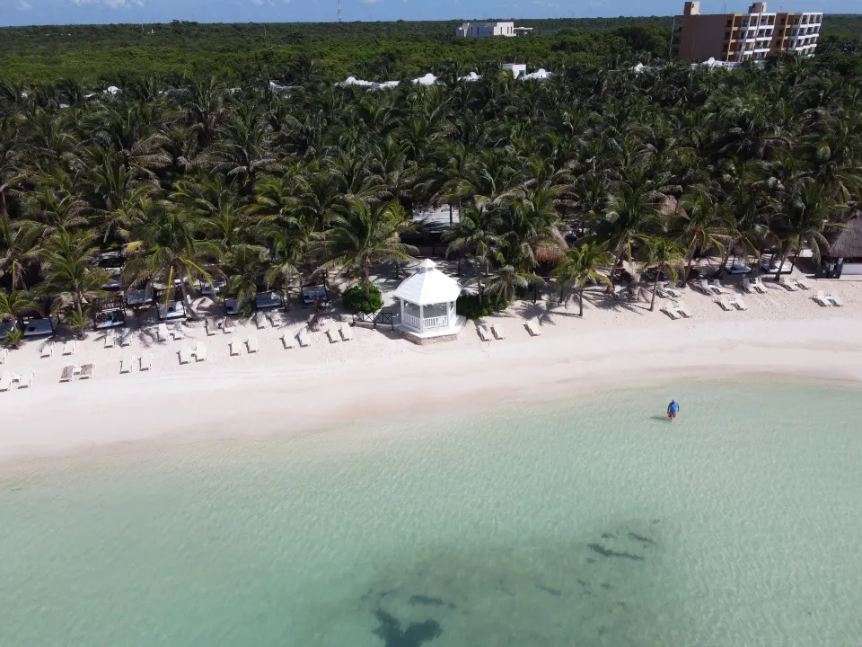 Front-facing aerial of the beach gazebo and shoreline at El Dorado Seaside Suites