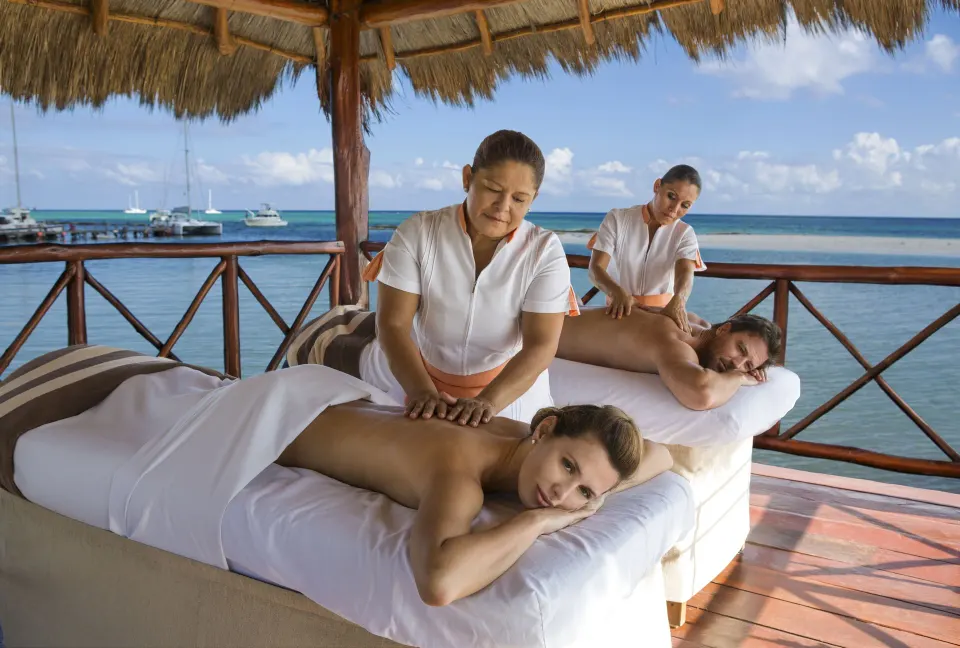 Couple receiving outdoor palapa massages overlooking the ocean at El Dorado Seaside Suites
