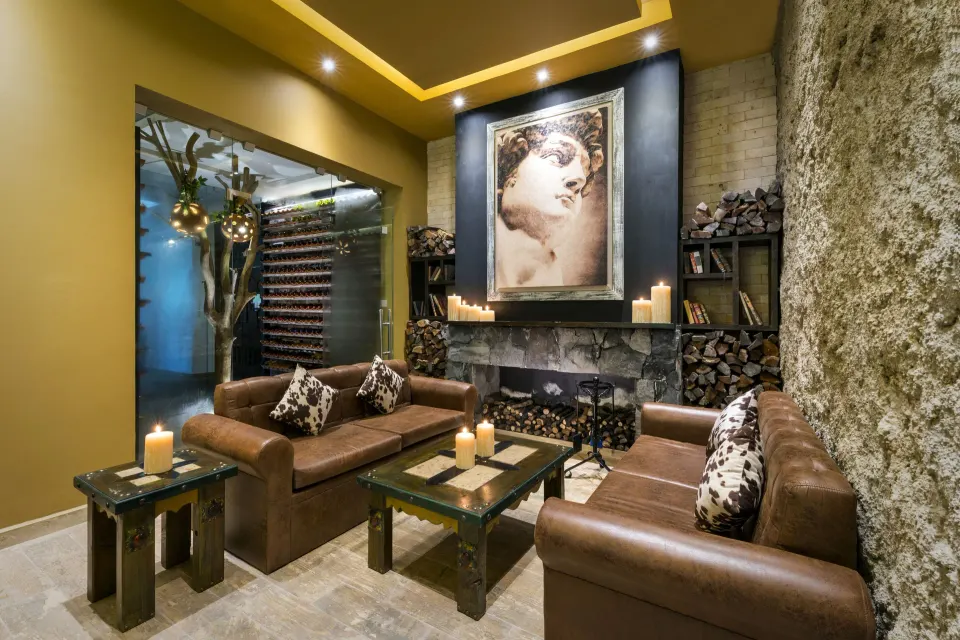 Cozy leather seating area with fireplace in a spa lounge at El Dorado Seaside Suites